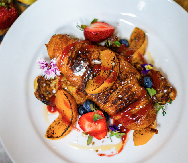Croissant french toast with peaches and strawberry coulis